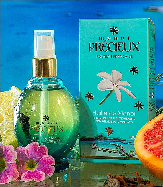 Frasco de óleo Monoi Précieux ao lado de sua embalagem turquesa, decorados com flores de Tiaré